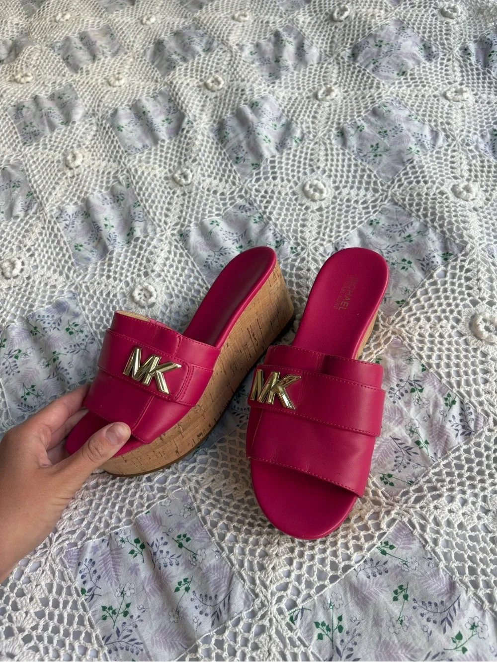 Michael Kors bright pink platform slide sandals with a cork wedge.